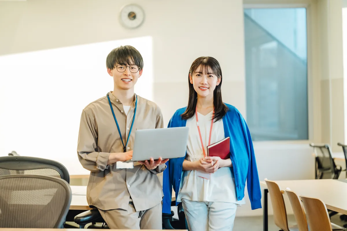 社内で表計算ソフトの台帳を見ながら働くお二人
